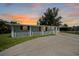 An exterior view of the home at sunset showcasing the front yard and driveway at 654 Aqui Esta Dr, Punta Gorda, FL 33950