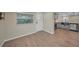 Bright kitchen with wood-look flooring, white door, and view of modern appliances at 654 Aqui Esta Dr, Punta Gorda, FL 33950