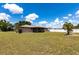 Spacious backyard enclosed by a white fence, featuring lush green grass and palm trees at 661 Athos Ter, Port Charlotte, FL 33952