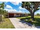 Charming single-story home with a well-maintained yard and a large tree providing ample shade at 661 Athos Ter, Port Charlotte, FL 33952