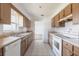 Kitchen with tile flooring, ample wood cabinetry, white appliances, and a view into the living area at 661 Athos Ter, Port Charlotte, FL 33952