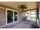A screened in back patio features a ceiling fan and views of the backyard at 661 Athos Ter, Port Charlotte, FL 33952