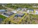 Aerial shot showcases property with pool, landscaping, and a neighborhood surrounded by lush greenery at 8117 Thruso Rd, Port Charlotte, FL 33981