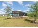 Wide view of the backyard with a screened-in patio, pool, and well-maintained grassy area at 8117 Thruso Rd, Port Charlotte, FL 33981