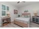 This bedroom features a window with shutters, gray-washed wood floors, and nautical decor at 8117 Thruso Rd, Port Charlotte, FL 33981