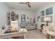 This office space features shutters, gray-washed wood floors, neutral walls, a loveseat, and a desk at 8117 Thruso Rd, Port Charlotte, FL 33981