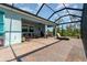 Spacious screened-in patio with a table, hot tub, lounge chair, and brick-paved floors, perfect for relaxation and entertaining at 8117 Thruso Rd, Port Charlotte, FL 33981