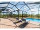Relaxing backyard pool with lounge chairs and a screened-in patio, providing a private outdoor oasis at 8117 Thruso Rd, Port Charlotte, FL 33981