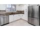 Modern kitchen with stainless steel appliances, white cabinets, and granite countertops at 814 Via Tripoli, Punta Gorda, FL 33950