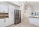 Bright kitchen featuring stainless steel refrigerator and adjoining staircase to upper level at 814 Via Tripoli, Punta Gorda, FL 33950
