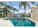 Enclosed pool area with waterfront views and lush tropical landscaping at 814 Via Tripoli, Punta Gorda, FL 33950