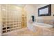 Bright bathroom features a large glass block shower and a soaking tub with tile surround at 95 N Marion Ct # 126, Punta Gorda, FL 33950