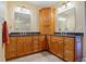 Well-lit bathroom with double sink, granite countertops, and honey-toned wood cabinetry at 95 N Marion Ct # 126, Punta Gorda, FL 33950