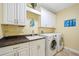 Bright laundry room with white cabinets, granite countertops, sink, and newer washer and dryer at 95 N Marion Ct # 126, Punta Gorda, FL 33950