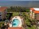 Aerial view of community pool and spa with tropical landscaping and views of the water at 95 N Marion Ct # 126, Punta Gorda, FL 33950
