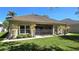 Back exterior view of home with lush green lawn at 2836 Suncoast Lakes Blvd, Punta Gorda, FL 33980