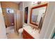 Well-lit bathroom featuring a vanity with sink, mirror, and tiled shower at 2836 Suncoast Lakes Blvd, Punta Gorda, FL 33980