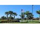 Picturesque community view with palm trees, a lake, and an American flag waving proudly at 2836 Suncoast Lakes Blvd, Punta Gorda, FL 33980