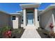 Inviting front entrance with light blue door and colorful landscaping at 10071 Sunday Dr, Port Charlotte, FL 33981
