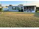 The rear of the home features a partially covered patio, lawn, and privacy at 123 Poinsettia Ne Cir, Port Charlotte, FL 33952