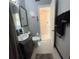 Bathroom features updated vanity, mirror, toilet, and tile flooring leading to a walk-in closet at 123 Poinsettia Ne Cir, Port Charlotte, FL 33952