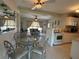 Open-concept dining area with glass table, tile flooring, open view to living room and adjacent kitchen at 123 Poinsettia Ne Cir, Port Charlotte, FL 33952