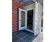 Open front door with decorative glass panel, welcomes you into this cozy home with a red brick accent wall at 123 Poinsettia Ne Cir, Port Charlotte, FL 33952