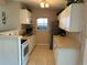 Functional kitchen featuring white cabinets, tile floors, and a serving bar at 123 Poinsettia Ne Cir, Port Charlotte, FL 33952