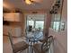Bright kitchen nook with glass table and sunroom view, perfect for casual dining at 123 Poinsettia Ne Cir, Port Charlotte, FL 33952