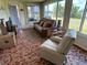 Inviting sun room with tiled floor, comfortable seating, large windows, and a view of the canal at 123 Poinsettia Ne Cir, Port Charlotte, FL 33952