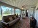Spacious sunroom with outdoor views, comfortable seating, and easy access to a restroom at 123 Poinsettia Ne Cir, Port Charlotte, FL 33952