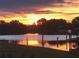 Beautiful sunset over the canal with trees silhouetted against the colorful sky at 123 Poinsettia Ne Cir, Port Charlotte, FL 33952