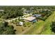 Enjoy an aerial perspective of the property set amongst large private lots and lush green landscaping at 1240 Alpinia Rd, North Port, FL 34288