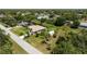 Aerial view showcasing the property with its outbuilding, large lawn, and proximity to wooded areas at 1240 Alpinia Rd, North Port, FL 34288