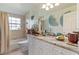 Well-lit bathroom with vanity, white cabinets, and decorative blue accents at 1240 Alpinia Rd, North Port, FL 34288