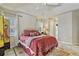 Bright bedroom with red and white bedding, ceiling fan, and lots of natural light at 1240 Alpinia Rd, North Port, FL 34288