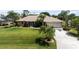 Charming single-story home featuring well-manicured lawn and mature palm trees, creating a welcoming curb appeal at 1240 Alpinia Rd, North Port, FL 34288