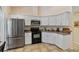 Functional kitchen featuring stainless steel appliances, white cabinetry, and light countertops at 1240 Alpinia Rd, North Port, FL 34288