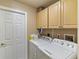 Functional laundry room with washer, dryer, and overhead storage at 1240 Alpinia Rd, North Port, FL 34288