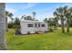 The property includes a charming outbuilding with double doors and a ramp, set amongst palm trees at 1240 Alpinia Rd, North Port, FL 34288