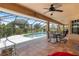 Screened-in patio with outdoor dining set and views of the pool and backyard at 1240 Alpinia Rd, North Port, FL 34288