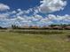 Wide view of backyards behind the property with pond and lush landscaping at 1263 Cicely Ct, North Port, FL 34289