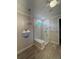 Modern bathroom featuring a glass shower with neutral tile and a decorative chandelier at 1263 Cicely Ct, North Port, FL 34289