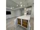Kitchen island with white cabinets, stainless steel appliances, and an open floor plan at 1263 Cicely Ct, North Port, FL 34289