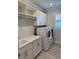 Bright laundry room featuring a sink, washer, dryer, and plenty of storage cabinets at 1263 Cicely Ct, North Port, FL 34289