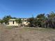 A backyard featuring a patio and tropical landscaping around the yellow home at 1270 Manor Rd, Englewood, FL 34223