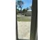 View of backyard and shed seen through glass patio doors at 1270 Manor Rd, Englewood, FL 34223