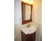 Bathroom featuring a pedestal sink with mirror, decorative accents, and a cabinet at 1270 Manor Rd, Englewood, FL 34223