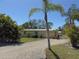 Charming single-story home with gravel drive, tropical landscaping, and sunny skies at 1270 Manor Rd, Englewood, FL 34223
