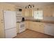 Well-lit kitchen with white appliances, neutral countertops, tiled floor, and window over sink at 1270 Manor Rd, Englewood, FL 34223